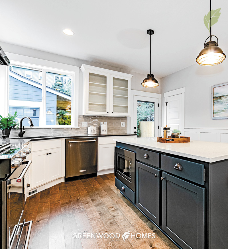 WEB-Greenwood_Gallery-10th(3365)4 View into a new kitchen with island, upper and lower cabinets and kitchen sink positioned in a corner under two windows.